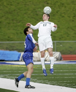 Kentwood’s Chandler Gray heads the ball away from Federal Way forward Nevin Hair. The Conks shut out the Eagles Tuesday.