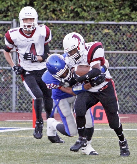 Kentlake's Giordan Smith breaks through Kent-Meridian tackles and gets a first and goal before getting wrapped up and taken down by KM's Brandon Harris.