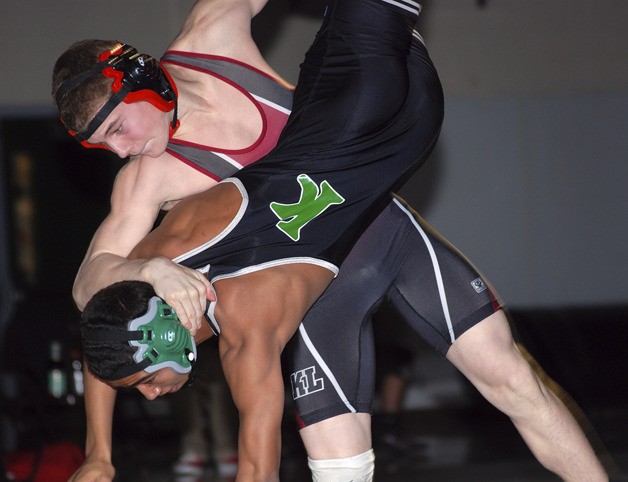 Kentlake’s Colton Marlowe lifts Kentwood’s Jamiel Jackson off his feet in a 145 pound match on Jan. 11. Marlowe pinned Jackson.