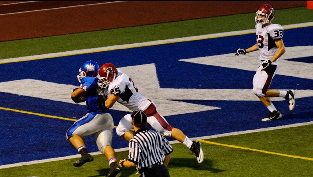 Kent-Meridian’s Vinnie Malietufa heads for the end zone in the second quarter while Kentlake safety Riley Higgins tries to bring the sophomore running back down.