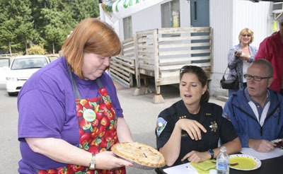 Councilwoman Victoria Laise-Jonas displays a pie for Police Chief Michelle Bennett and Mayor Noel Gerken to check out during the pie baking contest Saturday at the Maple Valley Farmers Market.