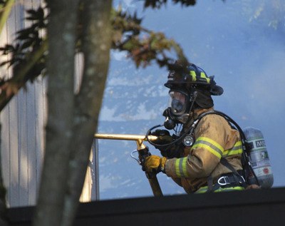 Kent Fire Department firefighters battle a home blaze Tuesday started by a discarded cigarette.