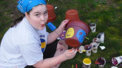 Crestwood Elementary student Hannah Simpson decorates flower pots to sell to raise money to pay for expenses related to her medical care.