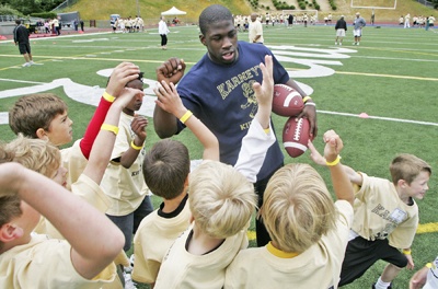 Demetrius Bronson huddles up with the kids at Mike Karney’s football camp.  Bronson