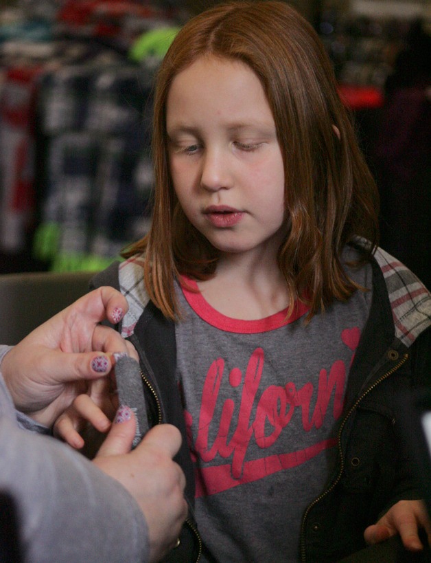 Cary Kemp watches as her nails are decorated at the Jamberry Nails booth Saturday during the Kentlake  Craft Fair.