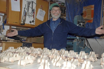 Toymaker Vern Heinle shows off some of his creations in his workshop at his home in Kent. He made more than 200 for needy children this year.