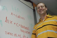 Dave Wright in his classroom at Tahoma High in front of the white board with a student interpretation of one of his math jokes.