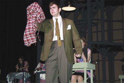 Kentlake student Daniel Lombard holds up a pair of pajamas in the opening scene of “The Pajama Game.”