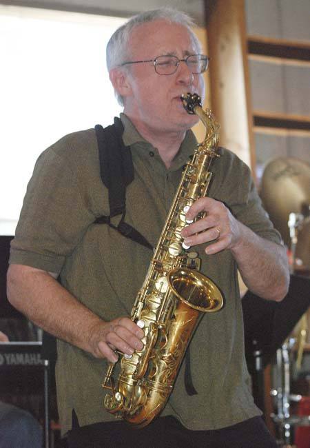 Doug Ostgard plays a solo on the saxophone with By Committee during a going out of business party for Baker Street Bookstore in Black Diamond on Sunday.