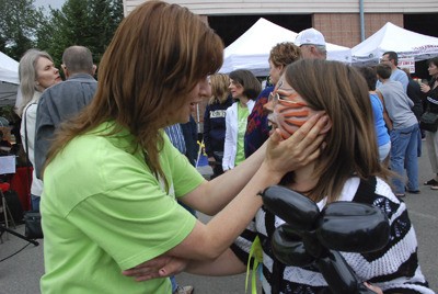 Kim Emmons checks out face painting work on her granddaughter Alex’s face at the opening day of the Maple Valley Farmer’s Market last year.